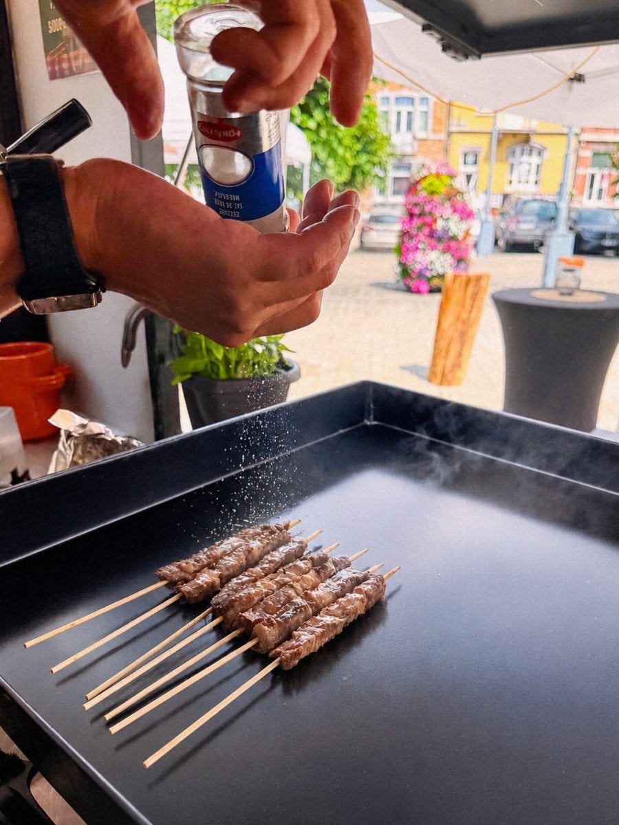 Le geste du sel sur les arrosticini, sur la plancha fumante